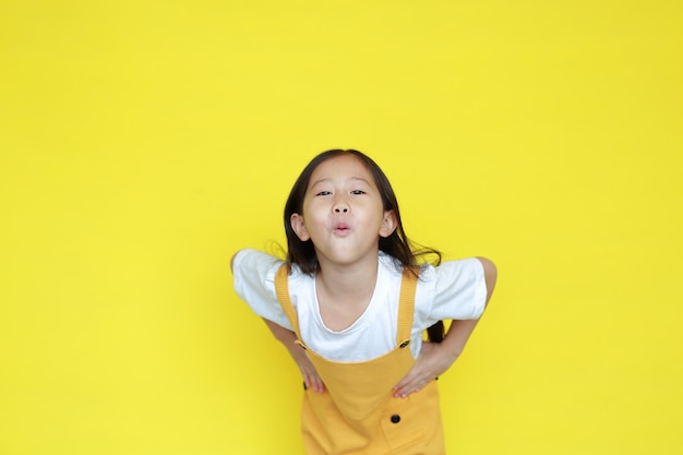 Cute little girl amazing expression isolated on yellow background