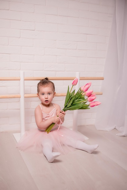 Cute little girl ballerina and her teacher doing exercises in ballet class