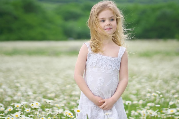 Cute little girl in big camomile meadow