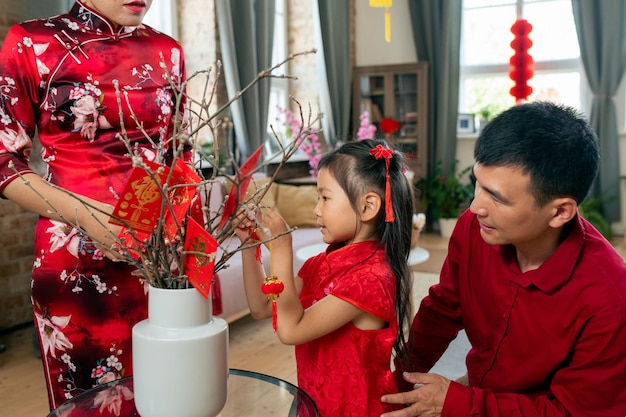 Cute little girl decorating branches with handmade postcards