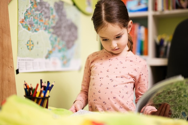 Cute little girl drawing in her room