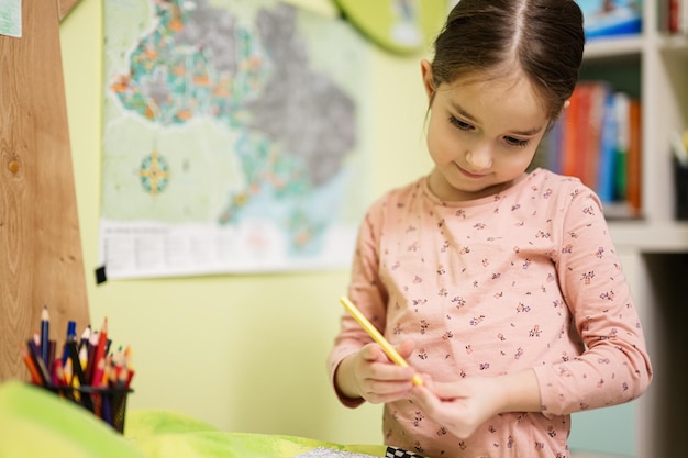 Cute little girl drawing in her room