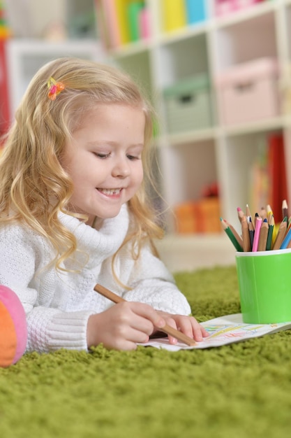 Cute little girl drawing in her room