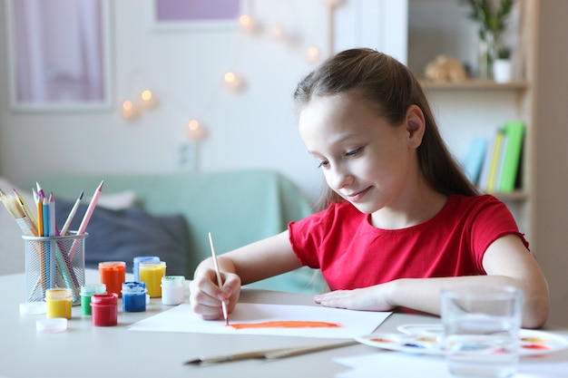 Cute little girl draws paints at home