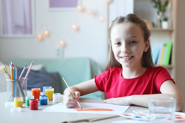 Cute little girl draws paints at home