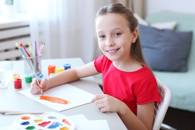 Cute little girl draws paints at home