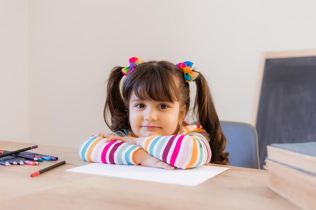 Cute little girl draws with colored pencils high quality photo