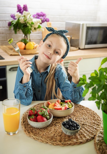 Cute little girl eats fruit salad