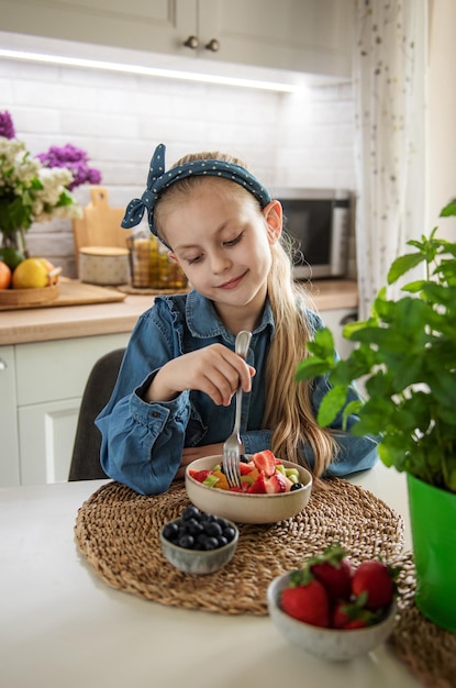 Cute little girl eats fruit salad