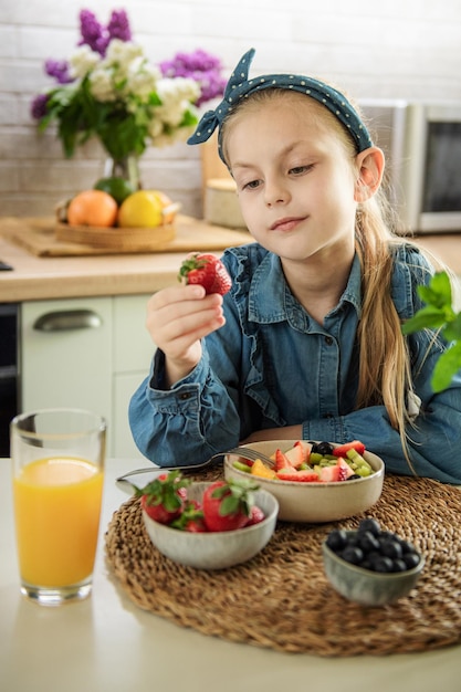 Cute little girl eats fruit salad