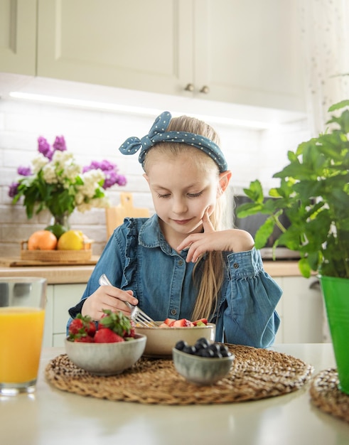 Cute little girl eats fruit salad