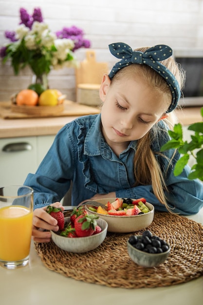 Cute little girl eats fruit salad