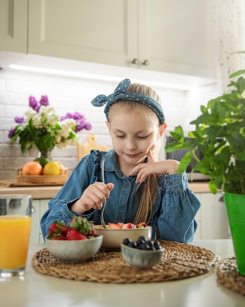 Cute little girl eats fruit salad