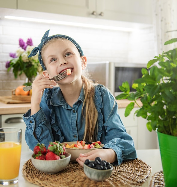 Cute little girl eats fruit salad