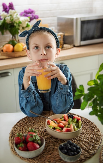 Cute little girl eats fruit salad