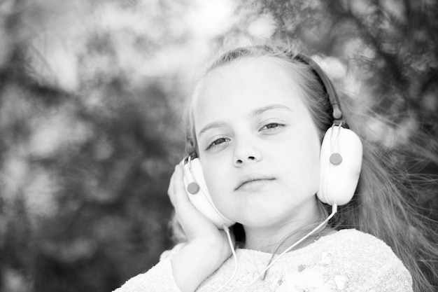 Cute little girl enjoying music using headphones