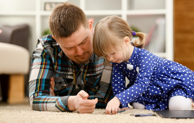 Photo cute little girl on floor carpet with dad use cellphone calling mom portrait life style apps social web network wireless ip telephony concept