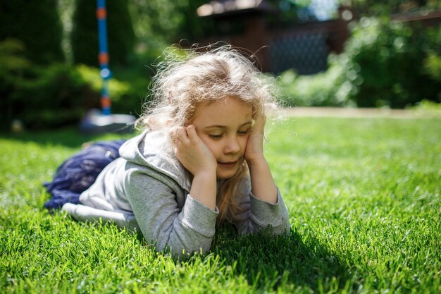 Cute little girl having fun at backyard at sunny spring day.