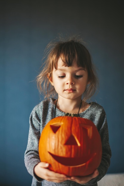 Cute little girl holding a Halloween pumpkin