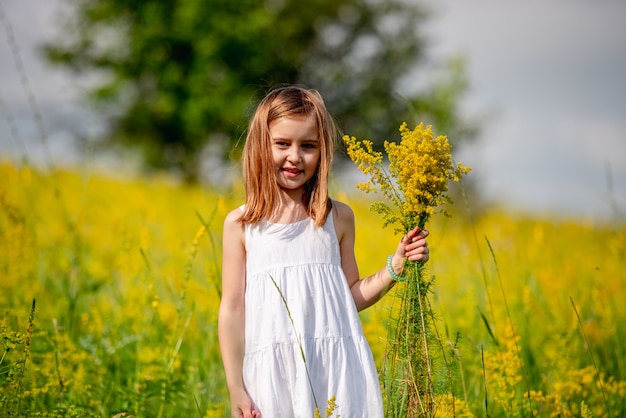 Cute little girl holding wildflower bouquet