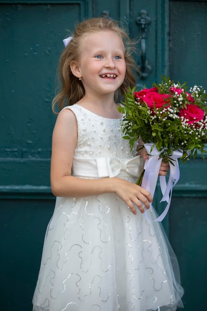 A cute little girl is holding a bouquet of flowers Women's Day