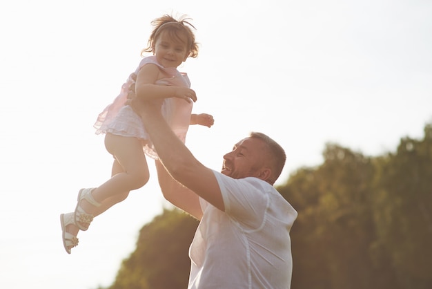 A cute little girl is spending time with her beloved grandfather in the park