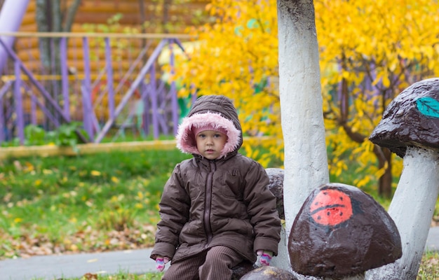 Cute little girl looking at camera in autumn park