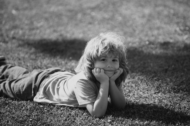 Cute little girl on the meadow in spring day happy childhood boy lying on grass cute kid child enjoy