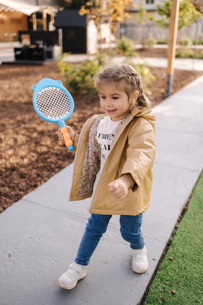 Cute little girl playing badminton in little kids city toy city for children