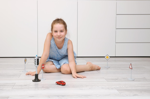 cute little girl playing at home on the floor with a typewriter road signs and traffic lights