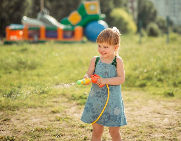 Cute little girl playing water gun