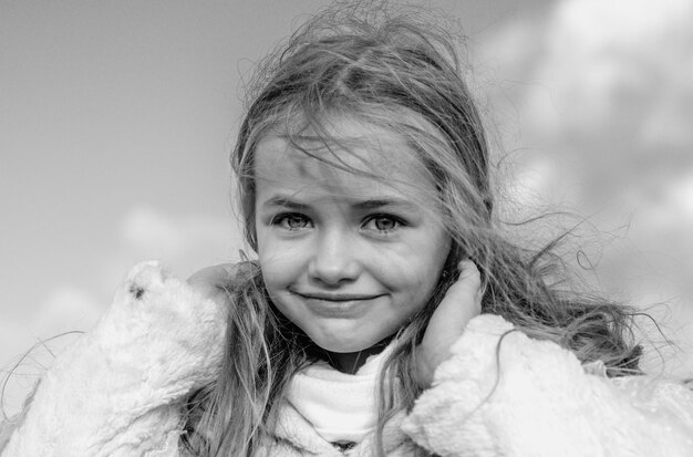 Photo cute little girl portrait on blue sky funny kids emotions outdoor close up portrait of a cute little