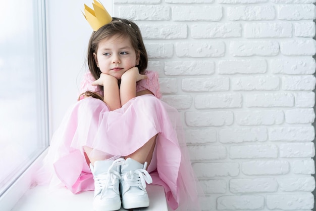 Photo cute little girl in a princess costume pretty child preparing for a costume party beautiful queen in gold crown