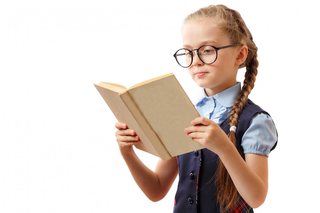 Cute little girl reads a book while wearing glasses, isolated on white