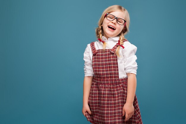 Cute little girl in red dress, white shirt and glasses