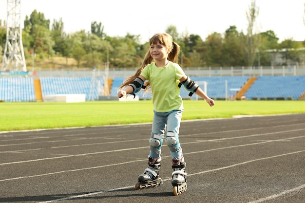 Cute little girl on roller skates on track