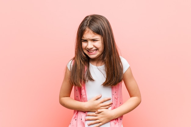 Cute little girl sick, suffering from stomachache, painful disease concept.