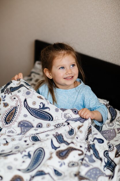 Cute little girl staying in bed