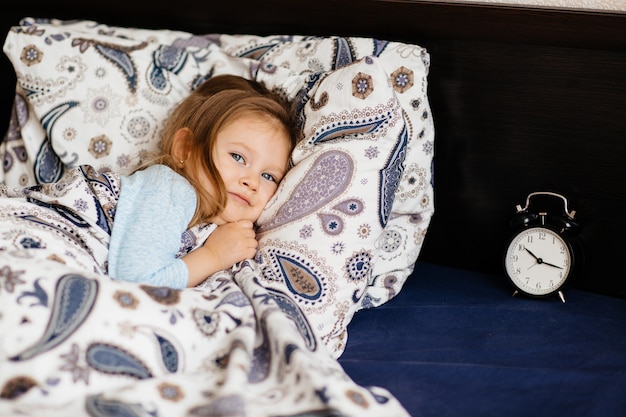 Cute little girl staying in bed