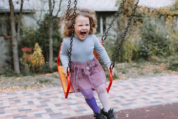 Cute Little girl on swing in park outdoor autumn card banner