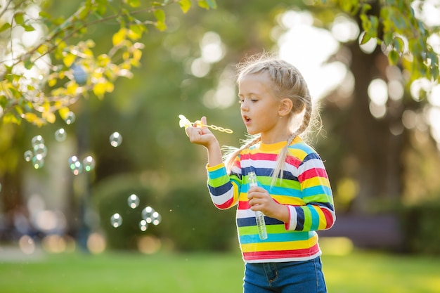 Cute little girl on a walk in a multi-colored knitted blouse