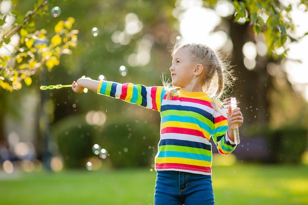 Cute little girl on a walk in a multi-colored knitted blouse