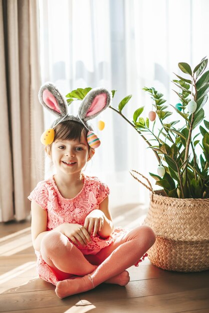 Cute little girl with bunny ears and painted eggs