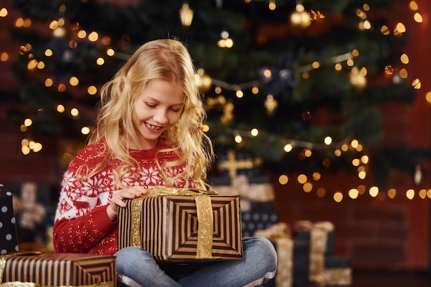 Cute little girl with gift boxes indoors celebrating new year and christmas holidays.