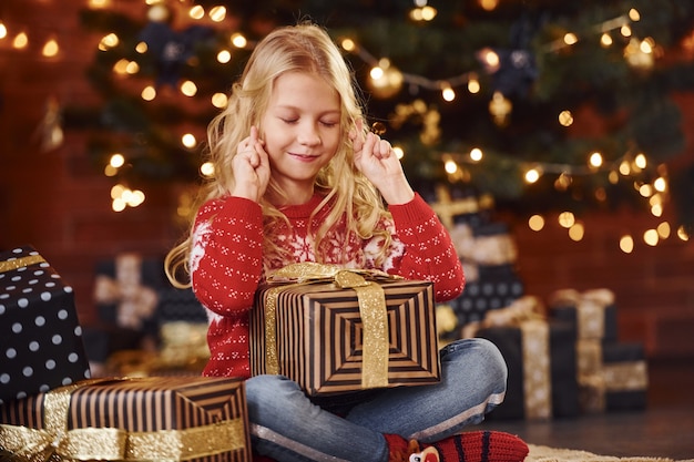 Cute little girl with gift boxes indoors celebrating new year and christmas holidays.