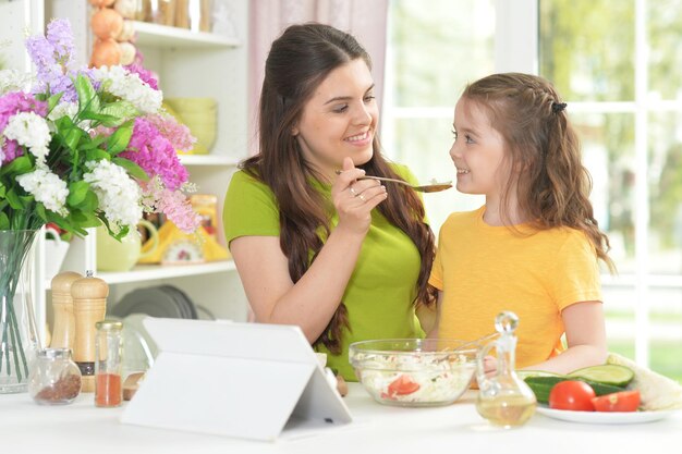 Cute little girl with her mother cooking together