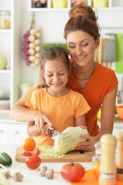 Cute little girl with her mother cooking together