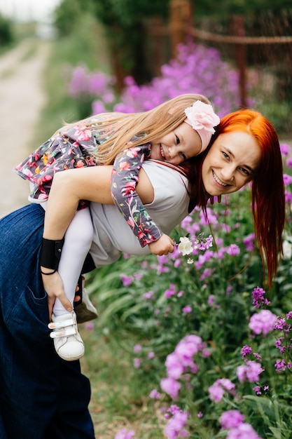 Cute little girl with her mother in a flower garden