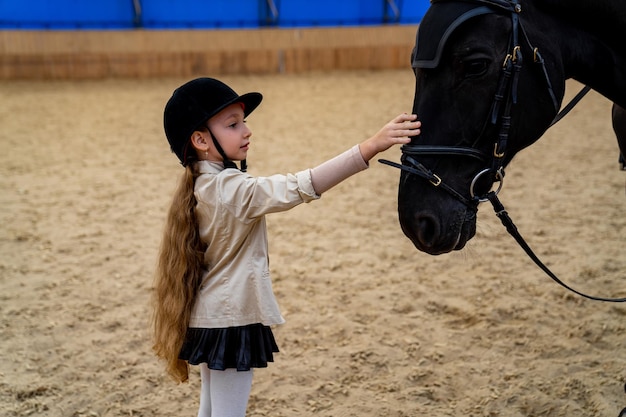 Cute little girl with horse on ranch Jockey training countryside