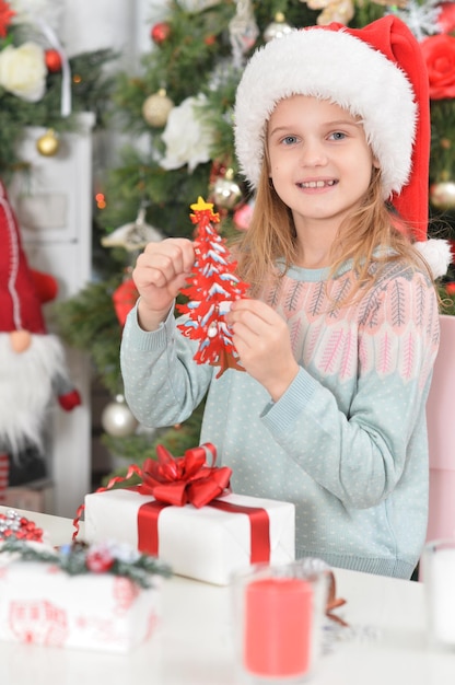 Cute little girl with New Year's gifts in Santa's hat